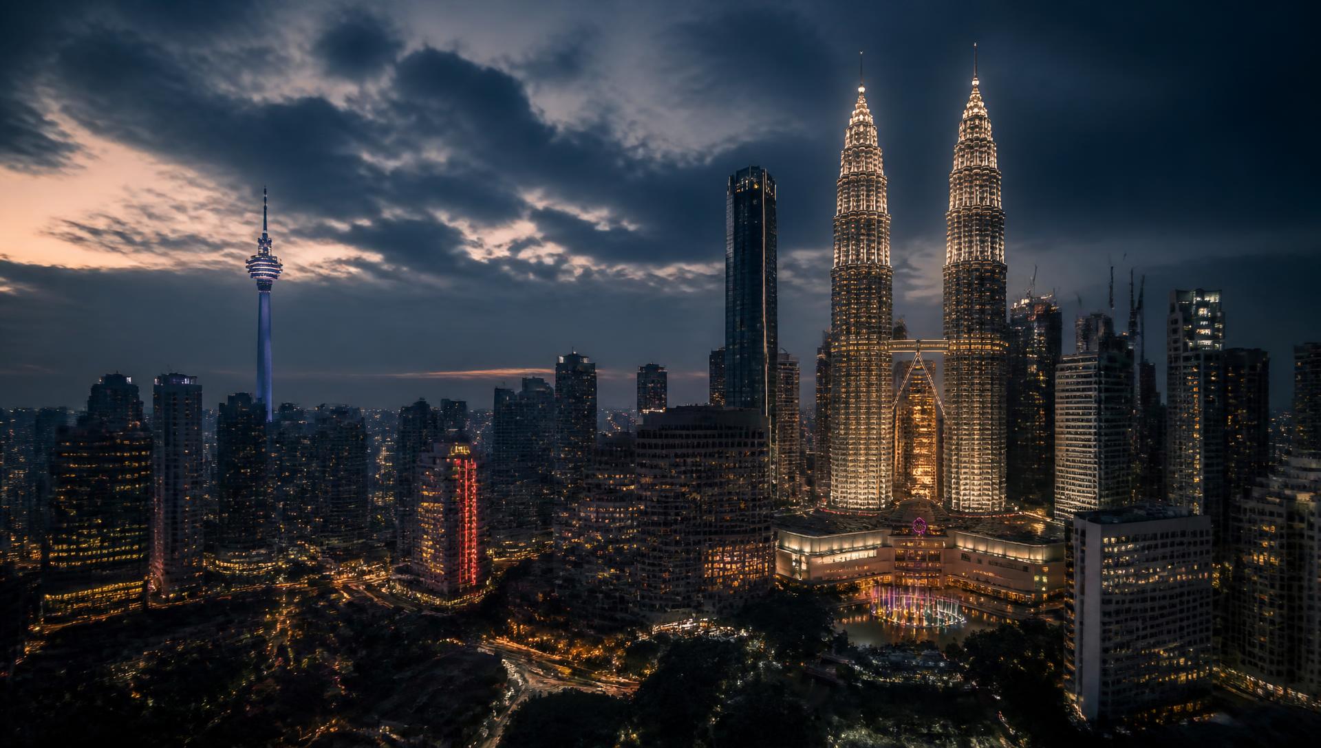 The Kuala Lumpur skyline at dusk, with the Petronas Twin Towers and KL Tower